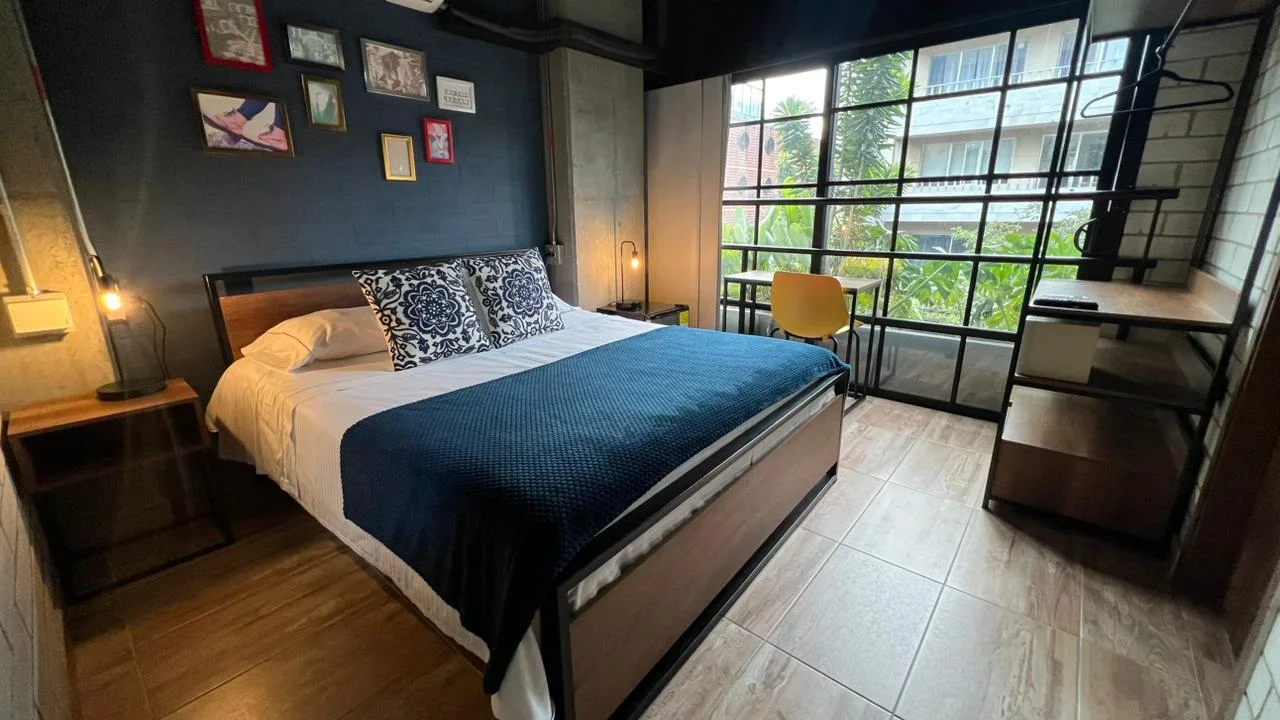 Deluxe: cama azul junto al ventanal